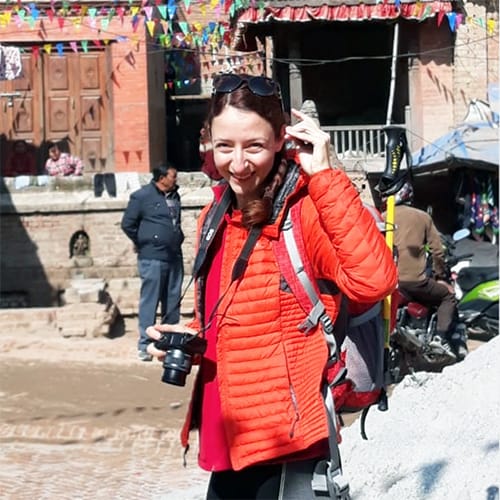 Michelle Della Giovanna from Full Time Explorer holds a camera while walking down the streets of Bhaktapur in Nepal