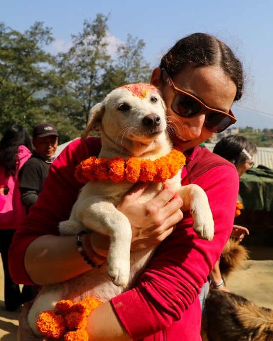 Michelle Della Giovanna from Full Time Explorer and a puppy on Kukur Tihar in Nepal