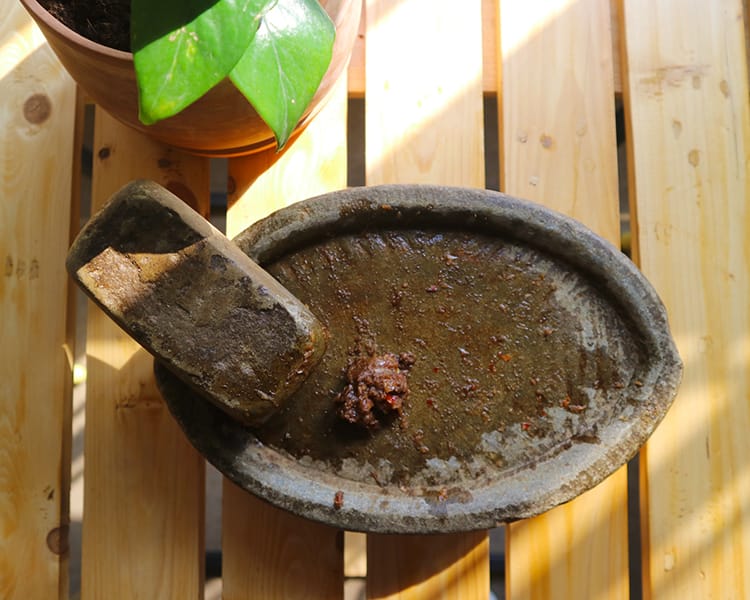 Chili, garlic, and timor ground together on a mortar