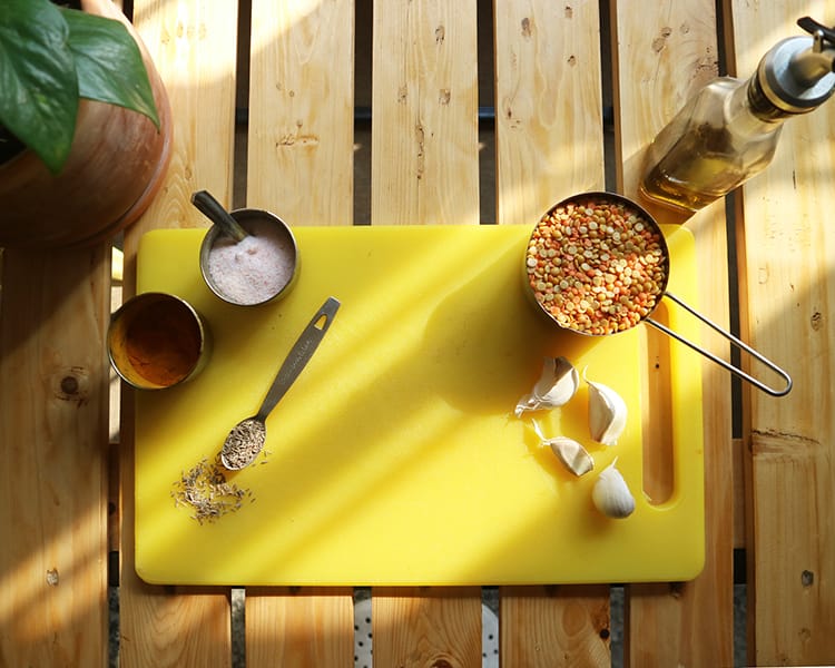 The ingredients to make yellow dal fry on a cutting board ready to prepare