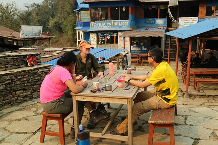 A group of trekkers play cards at a teahouse