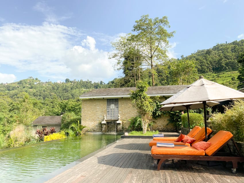 Lounge chairs sit by the pool at The Pavilions Himalaya the Farm