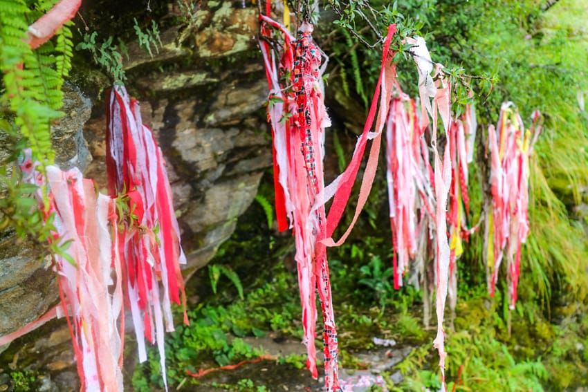 Pieces of Nepali scarves are shredded and hung near a tree for prayer