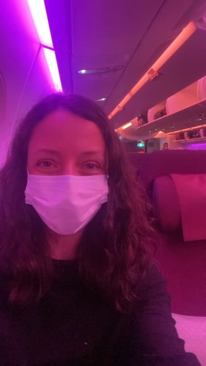Michelle Della Giovanna from Full Time Explorer sits in an airplane during the pandemic in 2022