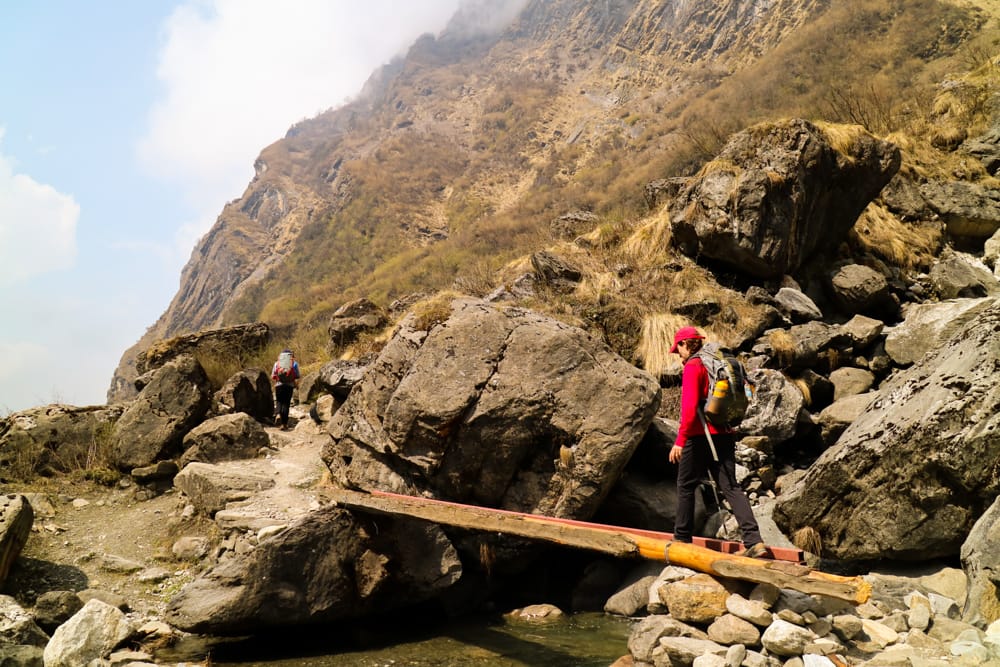 Michelle Della Giovanna from Full Time Explorer crosses a small bridge over a river
