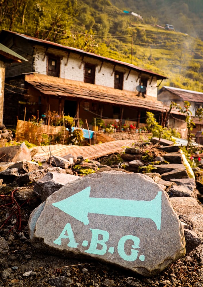 A rock with "ABC" and an arrow painted on it in blue directs trekkers towards the trail