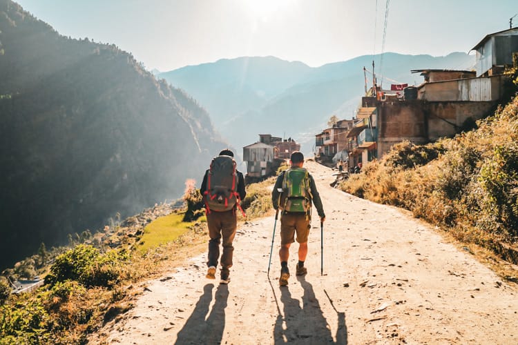 Two trekkers walk through Dhunche village on the way to Gosaikunda