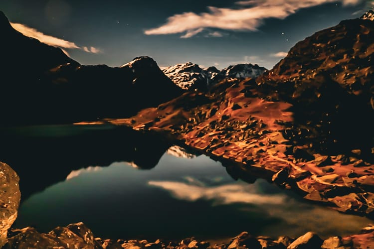 Gosaikunda Lake at night with the mountains reflecting in the water