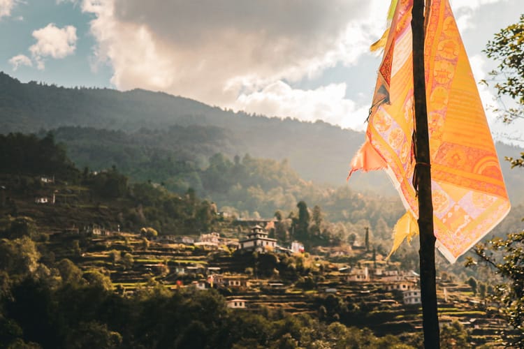 A prayer flag hangs in the sunlight in front of Nakote Ghyang, Nepal from across the valley