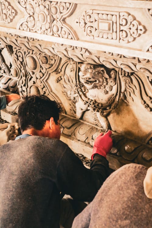 Artisans create designs in the cement of the new monastery