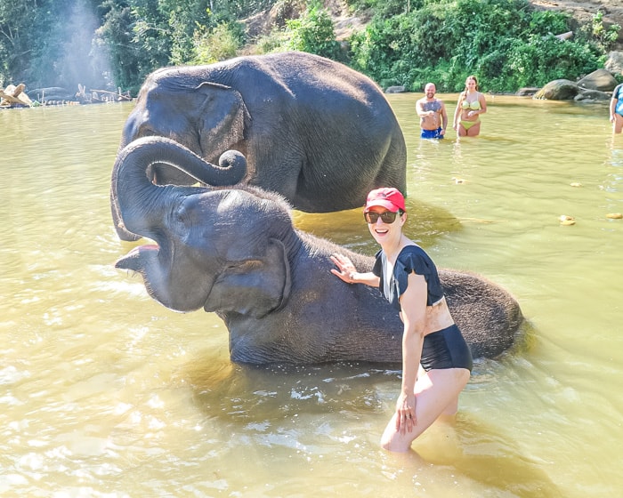 Michelle Della Giovanna with an elephant in the river at Into the Wild Elephant Camp in Chiang Mai
