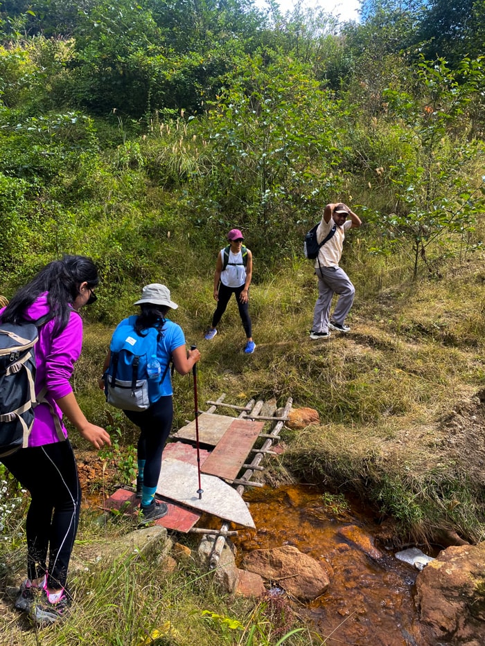 Hikers crossing a small river to try to find the path on the other side